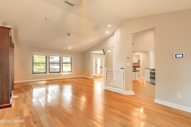 unfurnished living room featuring high vaulted ceiling and light hardwood / wood-style flooring