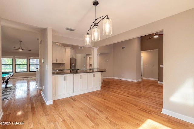 kitchen featuring white cabinets, ceiling fan, decorative light fixtures, light hardwood / wood-style floors, and stainless steel fridge