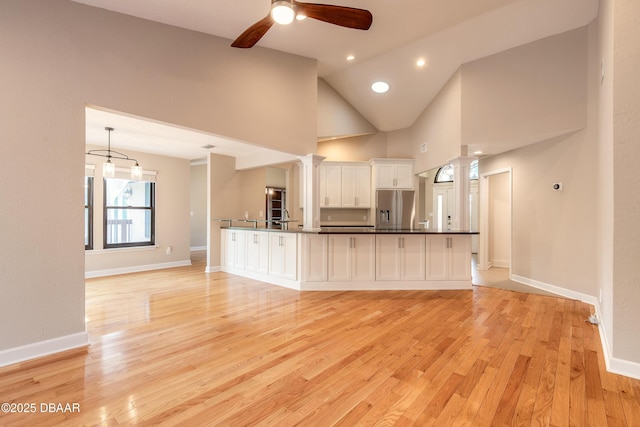 kitchen featuring light hardwood / wood-style flooring, stainless steel refrigerator with ice dispenser, ceiling fan, white cabinets, and ornate columns