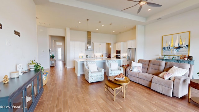 living room with a high ceiling, recessed lighting, ceiling fan, and wood tiled floor