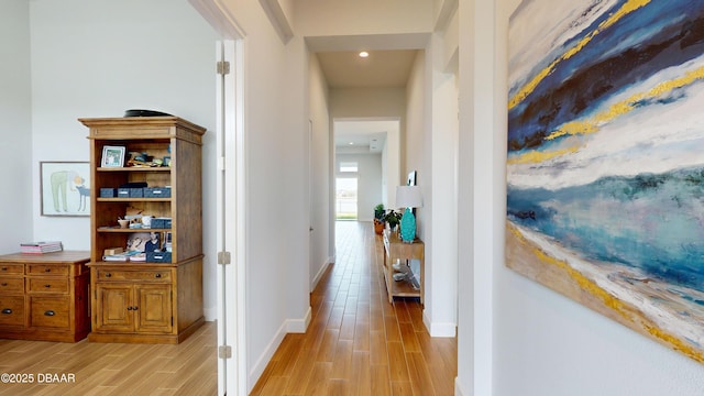 hall featuring baseboards and wood finish floors