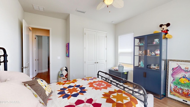 bedroom with wood finished floors, a closet, ceiling fan, and visible vents