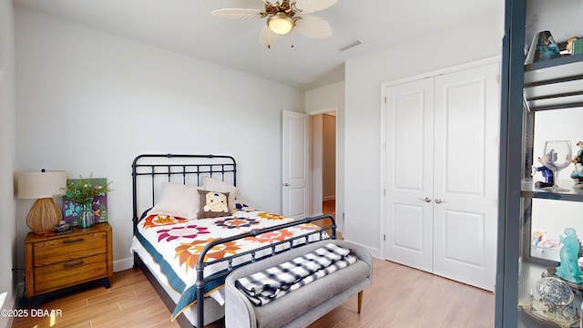 bedroom featuring a closet, baseboards, visible vents, light wood-style floors, and ceiling fan