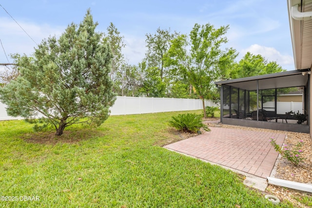 view of yard with fence, a sunroom, and a patio area