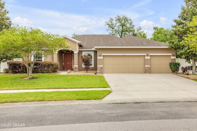 view of front of property with stucco siding, a garage, driveway, stone siding, and a front yard