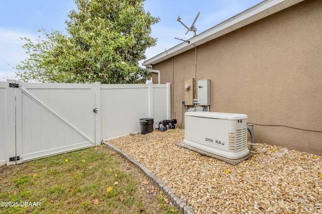 details with a gate, a power unit, electric meter, stucco siding, and fence