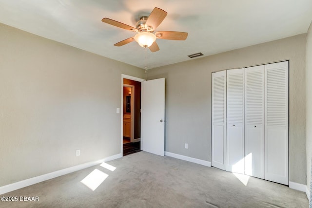 unfurnished bedroom with ceiling fan, light carpet, and a closet