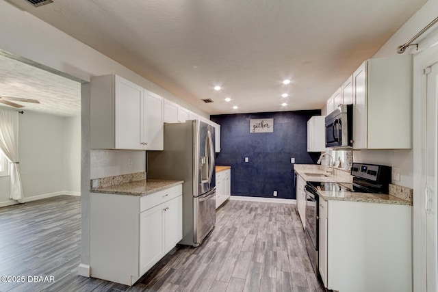 kitchen featuring sink, white cabinets, hardwood / wood-style floors, and appliances with stainless steel finishes