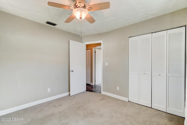 unfurnished bedroom featuring ceiling fan, light carpet, and a closet