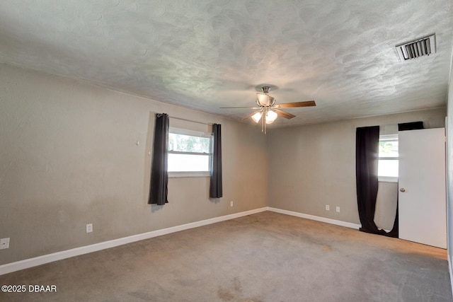 carpeted spare room with ceiling fan