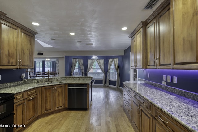 255 Woodhaven Cir W, Ormond Beach, FL 32174 - kitchen featuring dishwashing machine, black stove, a peninsula, light wood-style floors, and light stone counters