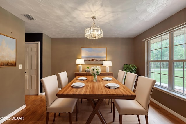 255 Woodhaven Cir W, Ormond Beach, FL 32174 - dining room featuring a chandelier and light wood-style flooring