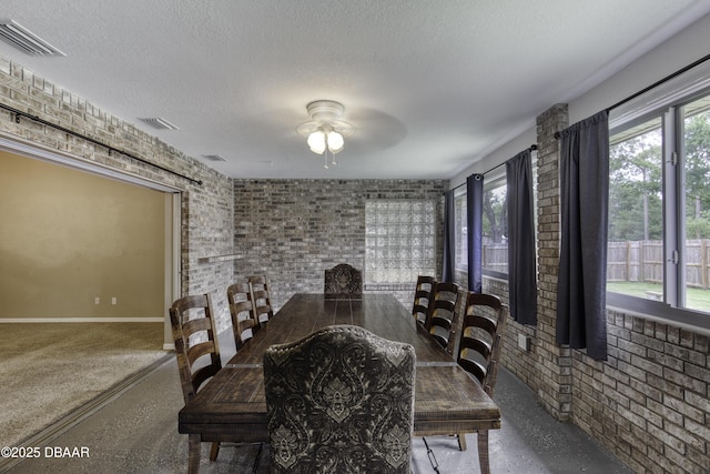 255 Woodhaven Cir W, Ormond Beach, FL 32174 - dining area featuring brick wall, ceiling fan, a textured ceiling, healthy amount of natural light, and speckled floor