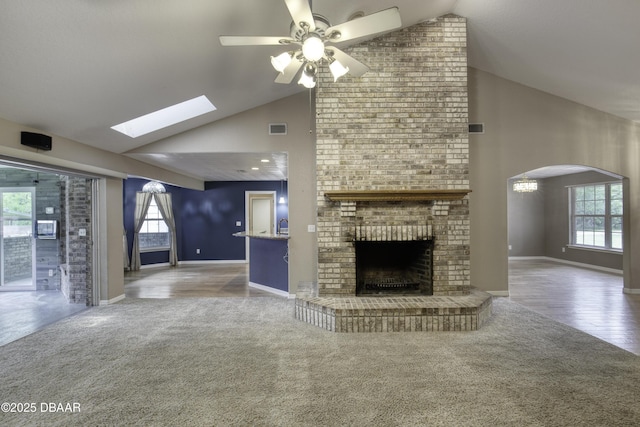 255 Woodhaven Cir W, Ormond Beach, FL 32174 - unfurnished living room featuring high vaulted ceiling, carpet floors, a fireplace, ceiling fan, and arched walkways