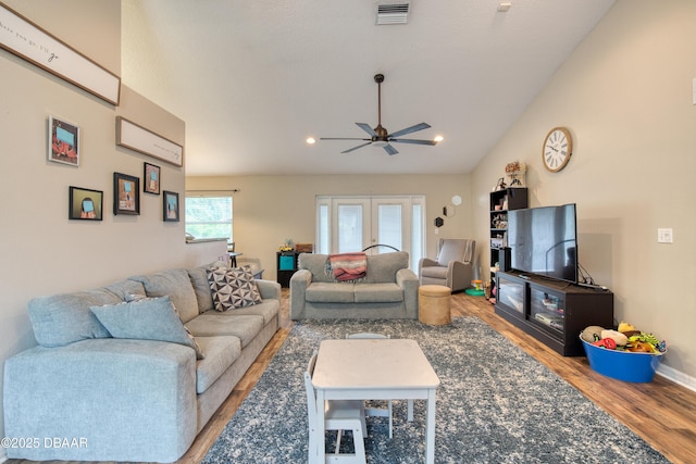 living room with vaulted ceiling, wood-type flooring, ceiling fan, and french doors