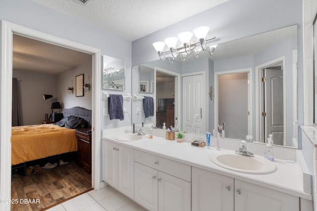 bathroom with tile patterned flooring, vanity, and a textured ceiling