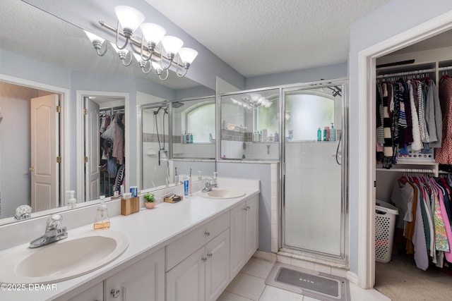 bathroom featuring vanity, tile patterned flooring, a textured ceiling, and walk in shower