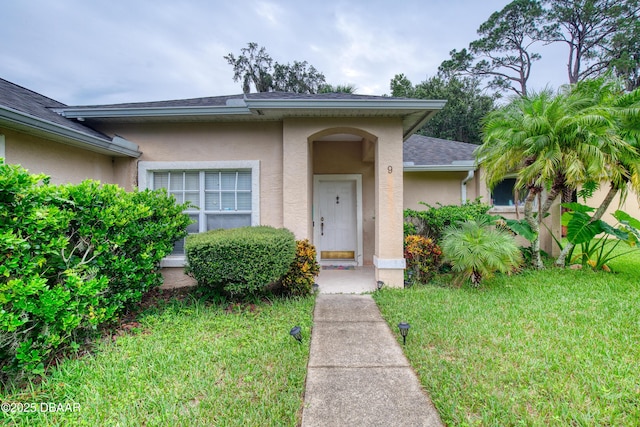 doorway to property featuring a lawn