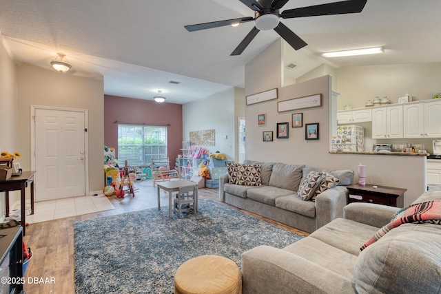 living room featuring high vaulted ceiling, light hardwood / wood-style floors, and ceiling fan