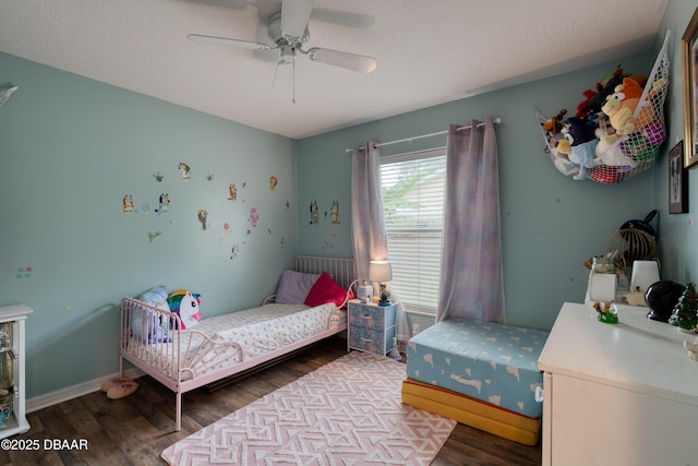 bedroom featuring ceiling fan, dark hardwood / wood-style floors, and a textured ceiling