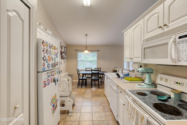 kitchen with light tile patterned flooring, lofted ceiling, hanging light fixtures, white appliances, and white cabinets