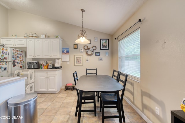 tiled dining space with lofted ceiling