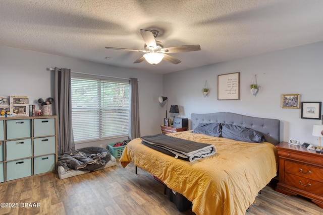 bedroom featuring ceiling fan, wood-type flooring, and a textured ceiling