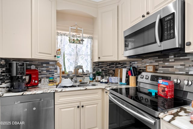 kitchen featuring stainless steel appliances, a sink, and white cabinets