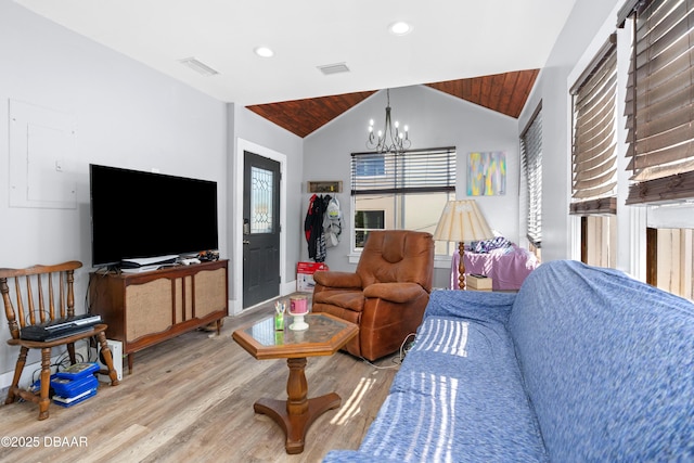 living room featuring lofted ceiling, wood finished floors, visible vents, and a notable chandelier