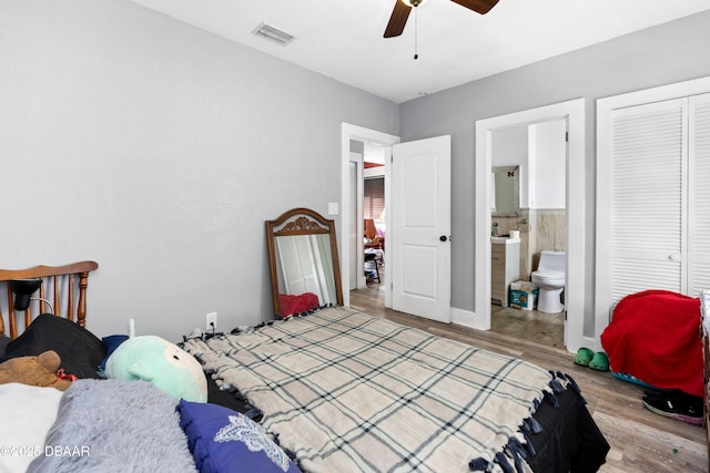 bedroom with ensuite bathroom, visible vents, a ceiling fan, a closet, and light wood finished floors