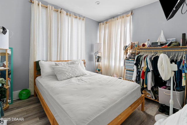 bedroom featuring multiple windows and wood finished floors