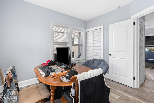 office area featuring a wealth of natural light, light wood-style flooring, and baseboards