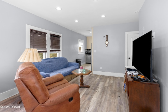 living room featuring light wood finished floors, baseboards, and recessed lighting