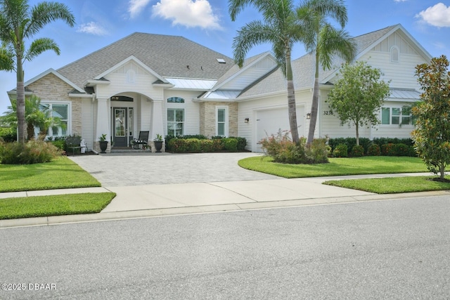 3236 Modena Way, New Smyrna Beach, FL 32168 - view of front of house with driveway, a front lawn, a garage, a standing seam roof, and a metal roof