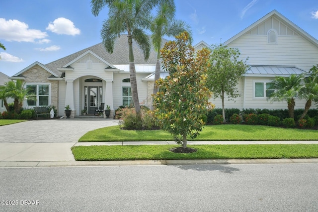 3236 Modena Way, New Smyrna Beach, FL 32168 - view of front facade featuring a front lawn, driveway, and a standing seam roof