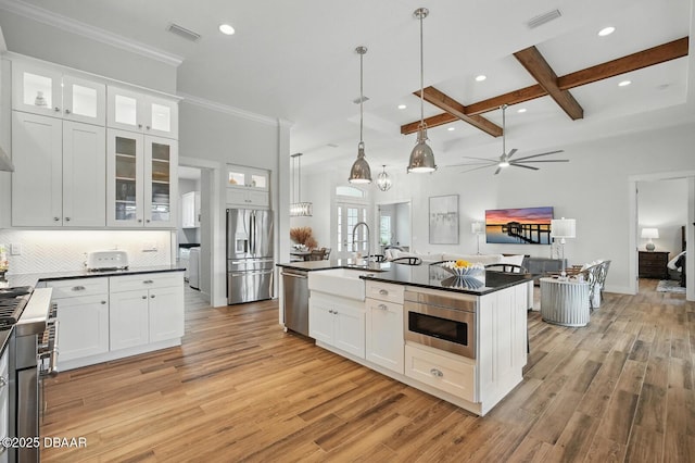 3236 Modena Way, New Smyrna Beach, FL 32168 - kitchen featuring stainless steel appliances, dark countertops, coffered ceiling, light wood-style floors, and recessed lighting