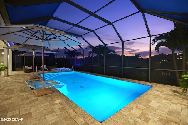 3236 Modena Way, New Smyrna Beach, FL 32168 - pool at dusk featuring a patio area, a pool with connected hot tub, and glass enclosure