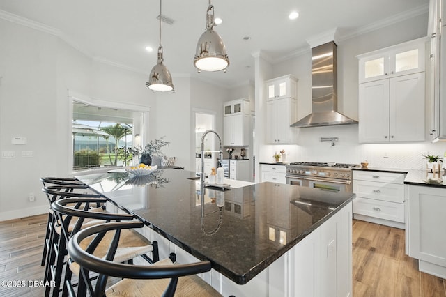 3236 Modena Way, New Smyrna Beach, FL 32168 - kitchen featuring wall chimney range hood, stainless steel range, crown molding, backsplash, and white cabinetry