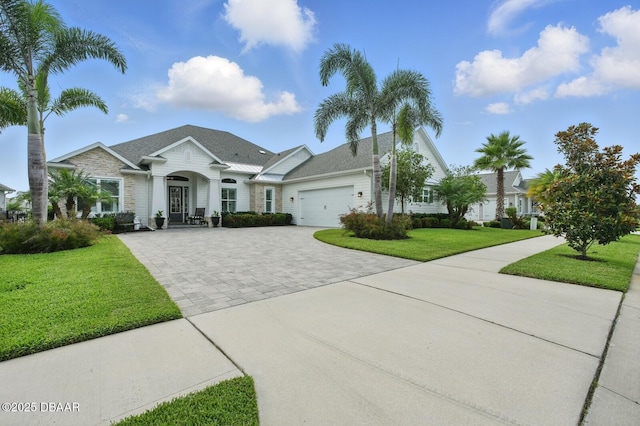 3236 Modena Way, New Smyrna Beach, FL 32168 - view of front of house featuring decorative driveway, an attached garage, and a front lawn
