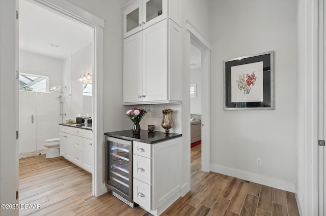 3236 Modena Way, New Smyrna Beach, FL 32168 - indoor bar with beverage cooler and light wood-style flooring