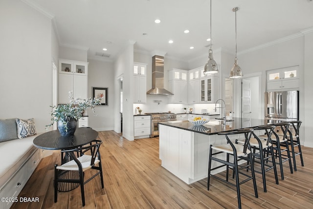 3236 Modena Way, New Smyrna Beach, FL 32168 - kitchen featuring wall chimney range hood, stainless steel appliances, dark countertops, a breakfast bar, and crown molding