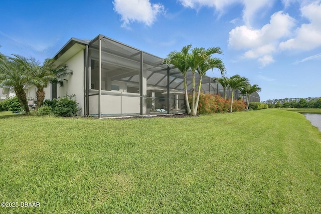 3236 Modena Way, New Smyrna Beach, FL 32168 - back of property featuring a yard, glass enclosure, a water view, and stucco siding