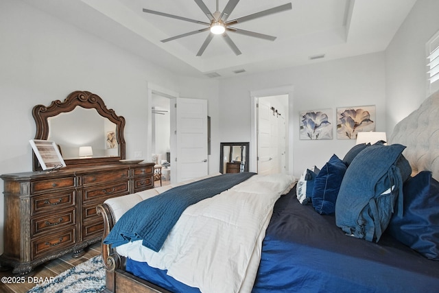 3236 Modena Way, New Smyrna Beach, FL 32168 - bedroom with a tray ceiling, wood finished floors, connected bathroom, and a ceiling fan