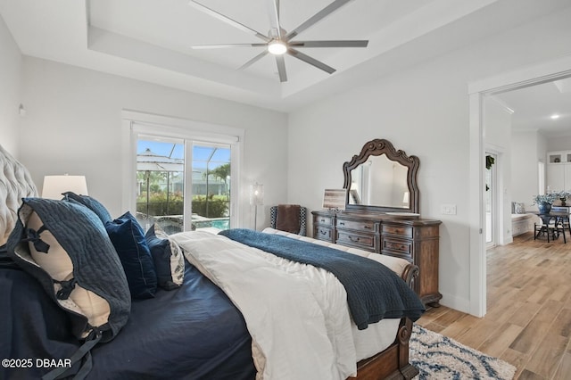 3236 Modena Way, New Smyrna Beach, FL 32168 - bedroom featuring access to exterior, light wood-type flooring, a raised ceiling, and a ceiling fan