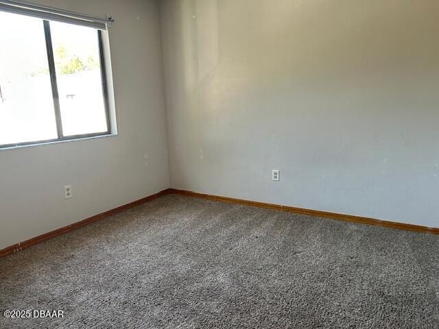 carpeted spare room with baseboards