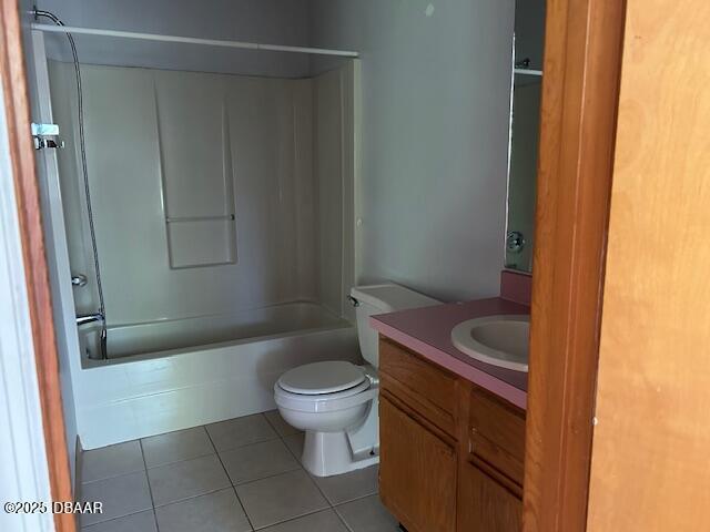 bathroom featuring tile patterned flooring, bathing tub / shower combination, toilet, and vanity