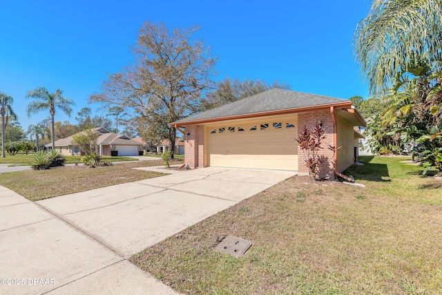 view of front facade with driveway, a shingled roof, an attached garage, a front lawn, and brick siding