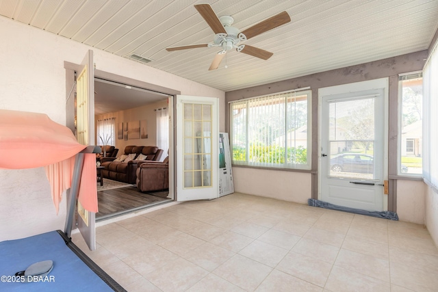 sunroom with ceiling fan, plenty of natural light, and visible vents