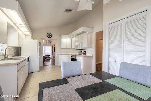 kitchen with appliances with stainless steel finishes, light countertops, light tile patterned flooring, and a sink