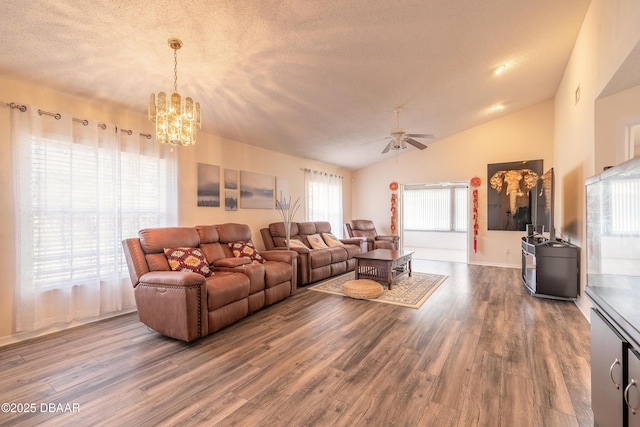 living room with ceiling fan with notable chandelier, lofted ceiling, a textured ceiling, and wood finished floors